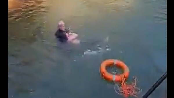 A screenshot from a video showing the British consul general saving a woman in China from drowning - Sputnik International