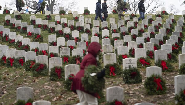 Volunteers lay holiday wreaths at headstones in Arlington National Cemetery during Wreaths Across America Day in Arlington, Va., Saturday, Dec. 14, 2019. Maine businessman Morrill Worcester started the annual event in 1992 at Arlington National Cemetery, and it has expanded to hundreds of veterans' cemeteries and other locations in all 50 states and overseas. (AP Photo/Sait Serkan Gurbuz) - Sputnik International