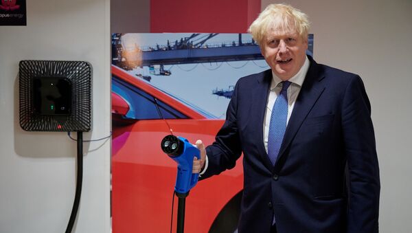 Britain's Prime Minister Boris Johnson holds a charging cable for an electric vehicle (EV), during his visit to the headquarters of energy supplier Octopus Energy in London on October 05, 2020 - Sputnik International