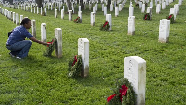 A woman places wreaths at gravesites during the 2015 National Wreaths Across America event at Arlington National Cemetery on December 12, 2015 in Arlington, Virginia - Sputnik International