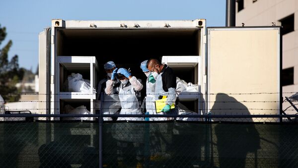El Paso County detention inmates, also known as ?trustees? (low level inmates) and Sheriff officers and morgue staff help move bodies to refrigerated trailers deployed during a surge of coronavirus disease (COVID-19) deaths, outside the Medical Examiner's Office in El Paso, Texas, U.S. November 14, 2020 - Sputnik International