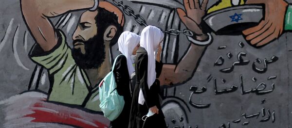 FILE PHOTO: Palestinian students walk past a mural depicting hunger-striking Palestinian prisoner Maher Al-Akhras, who is held by Israel, in the central Gaza Strip, 19 October 2020 FILE PHOTO: Palestinian students walk past a mural depicting hunger-striking Palestinian prisoner Maher Al-Akhras, who is held by Israel, in the central Gaza Strip, 19 October 2020 - Sputnik International