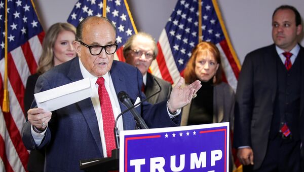 Former New York City Mayor Rudy Giuliani, personal attorney to US President Donald Trump, holds what he identifies as a replica mail-in ballot as he speaks about the 2020 US presidential election results during a news conference in Washington, 19 November 2020. REUTERS/Jonathan Ernst - Sputnik International