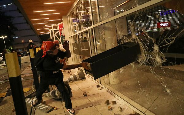 A demonstrator damages a storefront during a march in Sao Paulo on National Black Consciousness Day and in protest against the death of Joao Alberto Silveira Freitas, a Black man beaten to death at a market in Porto Alegre, Brazil, November 20, 2020 - Sputnik International