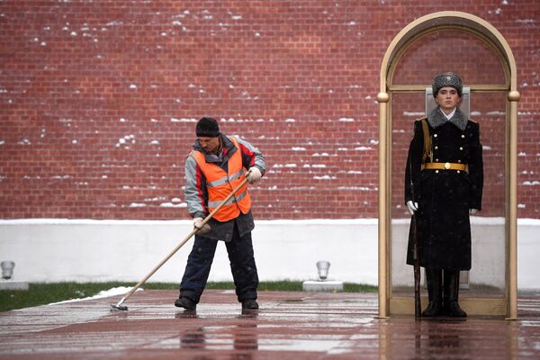 A janitor cleans the snow near the Tomb of the Unknown Soldier by the Kremlin wall - Sputnik International