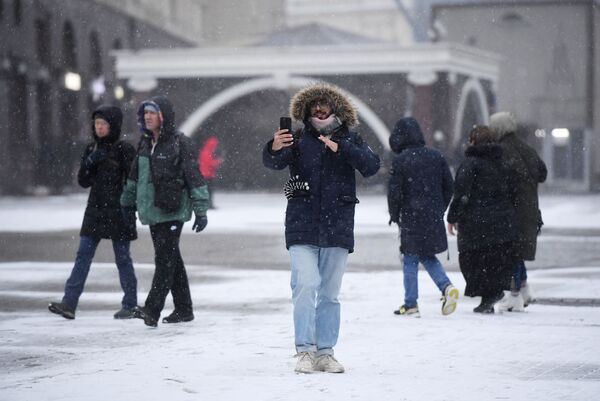A man takes a selfie with a snowy Moscow street in the background - Sputnik International