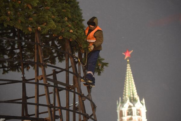 A worker installs an artificial Christmas tree in Red Square - Sputnik International
