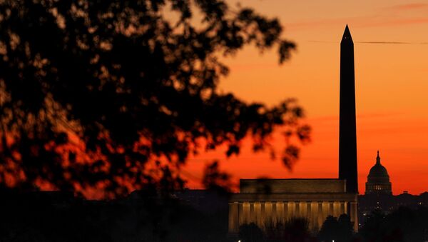 The sky turns shades of red as the sun rises behind the U.S. Capitol, the Washington Monument and the Lincoln Memorial in Washington, U.S., November 19, 2020.  - Sputnik International