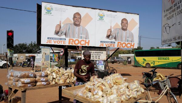A woman displays bread  for sale near a campaign banner of presidential candidate Roch Kabore in Ouagadougou, Burkina Faso November 20, 2020.  - Sputnik International