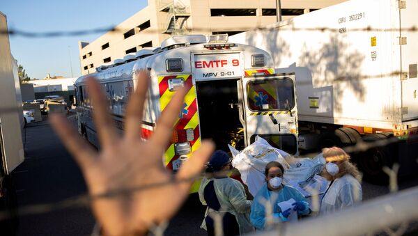 An El Paso County Sheriff's Officer tries to block photographs from being taken as bodies are moved to refrigerated trailers, deployed during a surge of coronavirus disease (COVID-19) deaths, outside the County of El Paso Medical Examiners Office in El Paso, Texas, 16 November 2020 - Sputnik International
