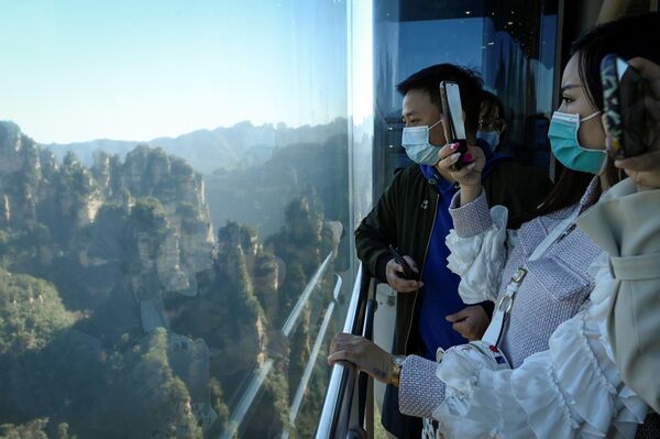 Tourists take pictures of the scenery as they ride the Bailong Elevator in  Zhangjiajie National Forest Park, China's Hunan province. - Sputnik International