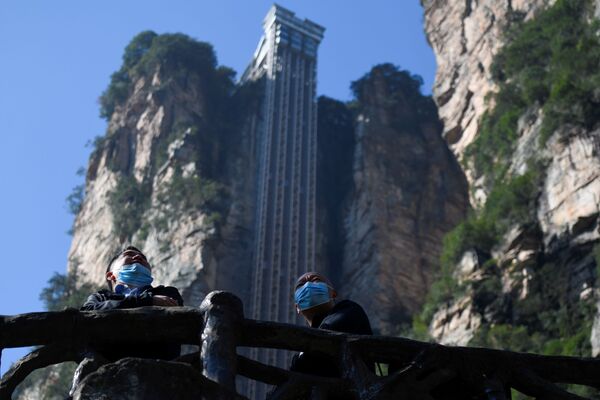 Two tourists wearing face masks look out in front of the Bailong Elevator in Zhangjiajie National Forest Park, China's Hunan province. - Sputnik International