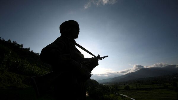 An Indian army soldier stands guard while patrolling near the Line of Control, a ceasefire line dividing Kashmir between India and Pakistan, in Poonch district August 7, 2013.  - Sputnik International