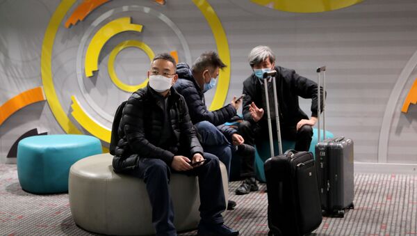 Travellers wearing face masks sit at Beijing Capital International Airport, following the global outbreak of the coronavirus disease (COVID-19), in Beijing, China November 22, 2020. - Sputnik International