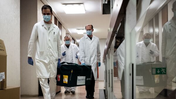 In this handout photo released by Hungarian Foreign Ministry, laboratory assistants carry a bag with Russia's coronavirus vaccine Gam-COVID-Vac, trade-named Sputnik V inside, in Budapest, Hungary - Sputnik International