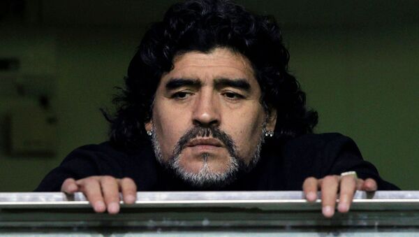 Former Argentine soccer star Diego Maradona watches from a balcony the Argentine first division soccer match between Boca Juniors and Banfield in Buenos Aires June 12, 2011. - Sputnik International
