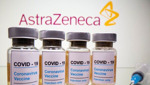 Vials with a sticker reading, COVID-19 / Coronavirus vaccine / Injection only and a medical syringe are seen in front of an AstraZeneca logo in this illustration taken 31 October 2020. - Sputnik International