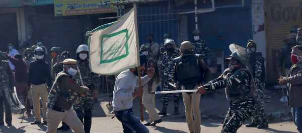 Policemen wield their batons against a farmer during a protest against the newly passed farm bills at Singhu border near Delhi, India - Sputnik International