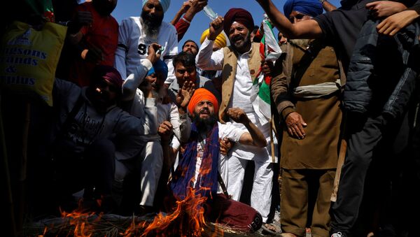 Farmers shout slogans after burning an effigy during a protest against the newly passed farm bills at Singhu border near Delhi, India, November 28, 2020.  - Sputnik International