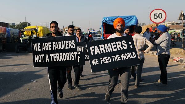 Farmers carry placards at a site of a protest against the newly passed farm bills at Singhu border near Delhi, India, November 28, 2020 - Sputnik International