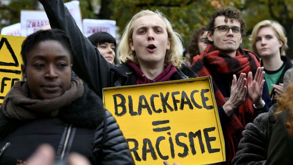 A man holds a sign as he protests against the arrival of Saint Nicholas and his assistants called Zwarte Piet (Black Pete) in The Hague, Netherlands, November 16, 2019. The sign reads Blackface is racism.  - Sputnik International