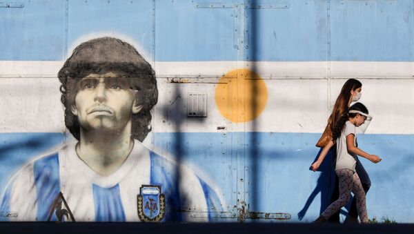 People walk past graffiti featuring soccer legend Diego Armando Maradona in Buenos Aires, Argentina, 27 November 2020 - Sputnik International