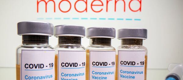 Vials with a sticker reading, COVID-19 / Coronavirus vaccine / Injection only and a medical syringe are seen in front of a displayed Moderna logo in this illustration taken October 31, 2020.  - Sputnik International