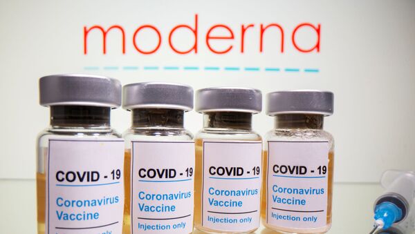 Vials with a sticker reading, COVID-19 / Coronavirus vaccine / Injection only and a medical syringe are seen in front of a displayed Moderna logo in this illustration taken October 31, 2020.  - Sputnik International