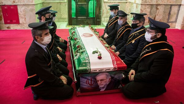 Mourners sit next to the coffin of Iranian nuclear scientist Mohsen Fakhrizadeh, during the burial ceremony at the shrine of Imamzadeh Saleh, in Tehran, Iran November 30, 2020. - Sputnik International