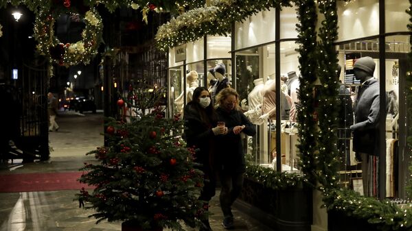 Women wearing face masks walk past a Christmas tree and lights in Burlington Arcade, where all non-essential shops are temporarily closed during England's second coronavirus lockdown, in London, Wednesday, Nov. 25, 2020 - Sputnik International