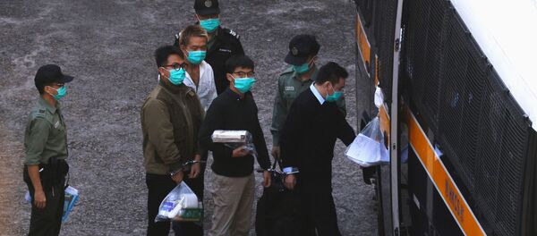 Pro-democracy activists Ivan Lam and Joshua Wong walk to a prison van to head to court, after pleading guilty to charges of organising and inciting an unauthorised assembly near the police headquarters during last year's anti-government protests, in Hong Kong, China December 2, 2020 Pro-democracy activists Ivan Lam and Joshua Wong walk to a prison van to head to court, after pleading guilty to charges of organising and inciting an unauthorised assembly near the police headquarters during last year's anti-government protests, in Hong Kong, China December 2, 2020 - Sputnik International
