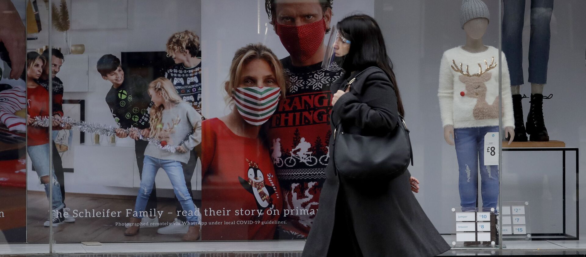 A woman wearing a face shield walks past the front window of the Primark clothing store on Oxford Street during England's second coronavirus lockdown, in London, Monday, Nov. 23, 2020 - Sputnik International, 1920