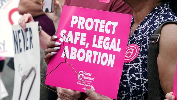 An abortion rights activist holds a sign in downtown Memphis during a Stop Abortion Bans Day of Action rally hosted by the Tennessee chapter of Planned Parenthood in Tennessee, U.S., May 21, 2019 - Sputnik International