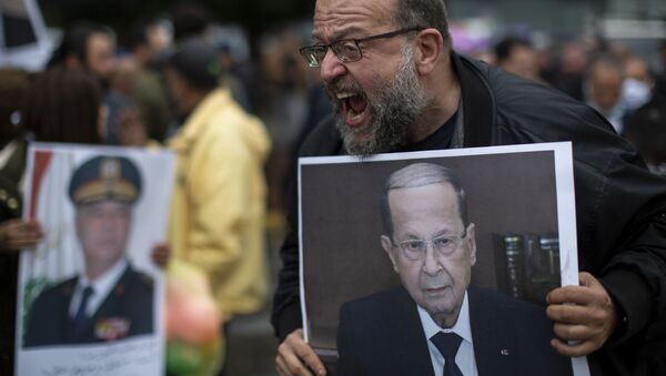 An anti-government protester holds a picture of Lebanese President Michel Aoun as he shouts slogans during a protest, in Beirut's Ashrafieh district, Lebanon, Thursday, Nov. 26, 2020. - Sputnik International