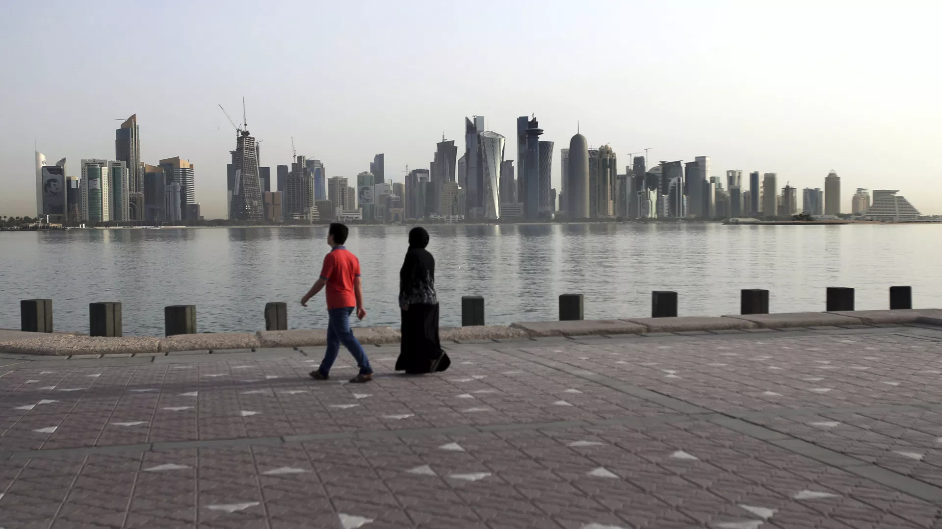 In this Friday, May 4, 2018, photo, a couple walk by the sea with the city skyline in the background, in Doha, Qatar - Sputnik International, 1920, 27.07.2026
