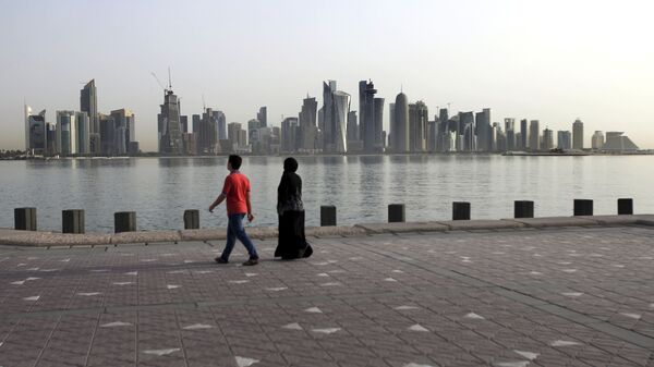 In this Friday, May 4, 2018, photo, a couple walk by the sea with the city skyline in the background, in Doha, Qatar - Sputnik International