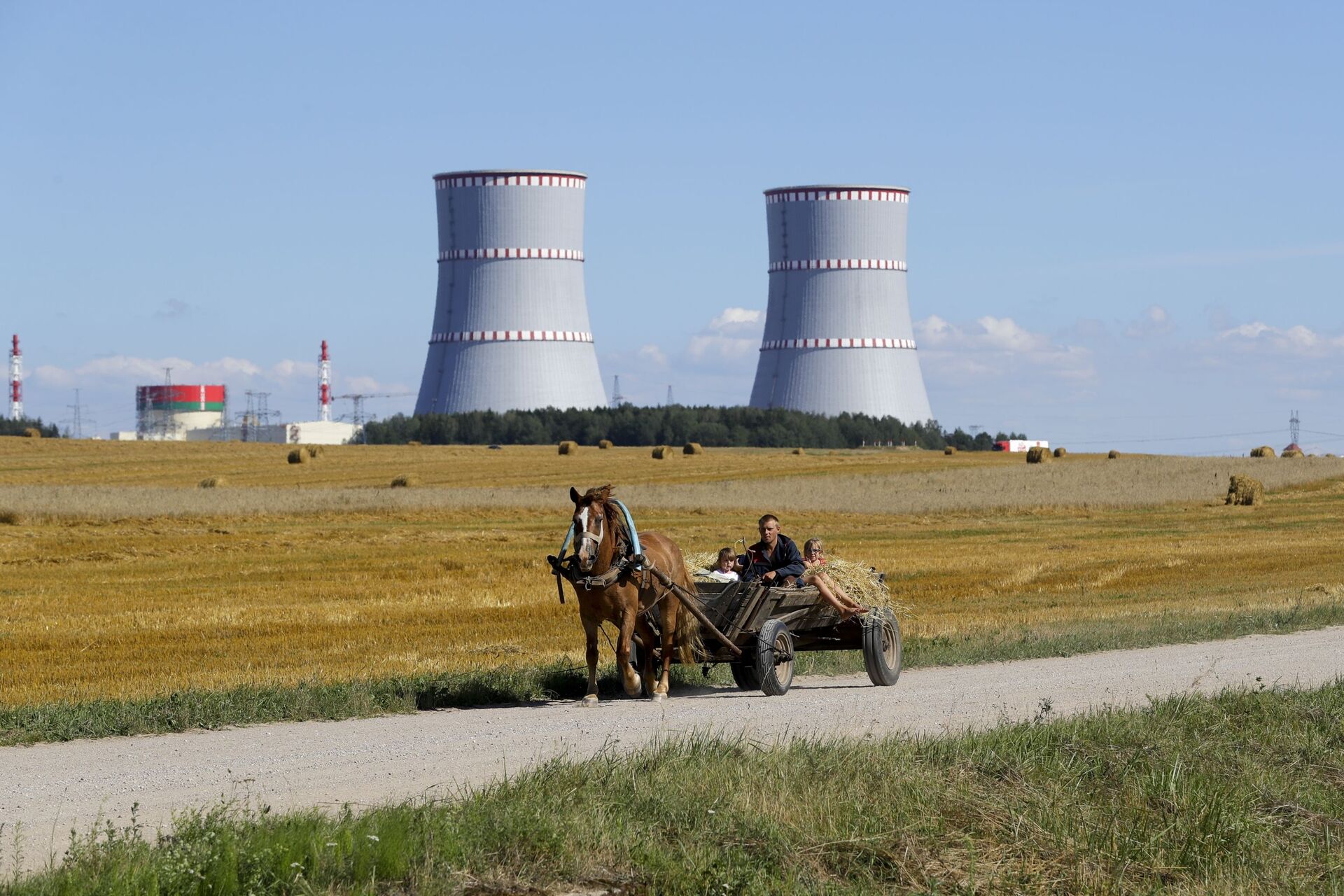 A man in a horse drawn carriage travels on a road, with Belarus's first nuclear plant which was built by Russia's state nuclear corporation Rosatom in the background near Astravets, Belarus, Friday, Aug. 7, 2020 - Sputnik International, 1920, 15.06.2022