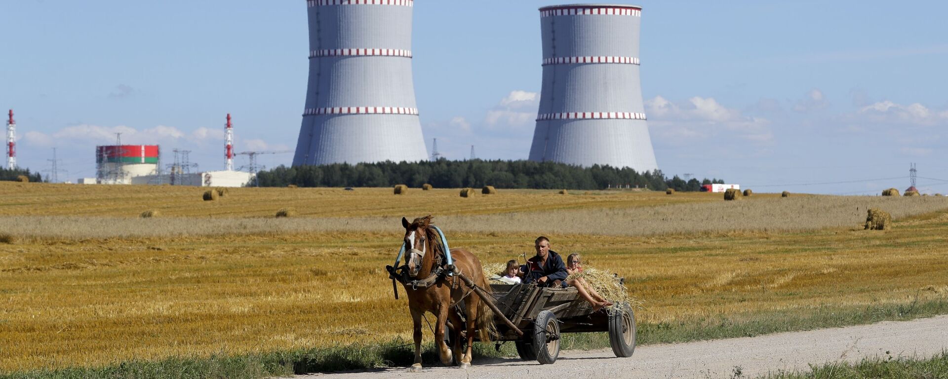 A man in a horse drawn carriage travels on a road, with Belarus's first nuclear plant which was built by Russia's state nuclear corporation Rosatom in the background near Astravets, Belarus, Friday, Aug. 7, 2020 - Sputnik International, 1920