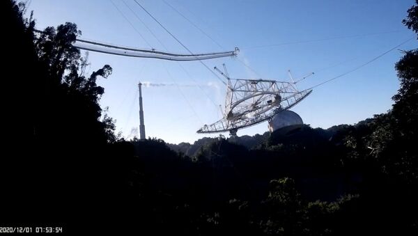 Screenshot shows the exact moment in which the cables attached to the Arecibo Observatory's radio telescope snap and send the structure crashing down to the dish platform. - Sputnik International
