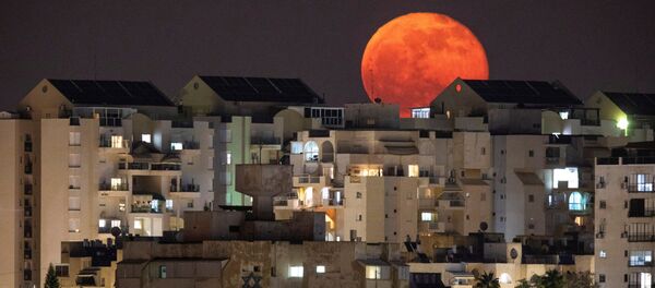 Полная луна за зданиями в Ашкелоне, на юге Израиля - Sputnik International