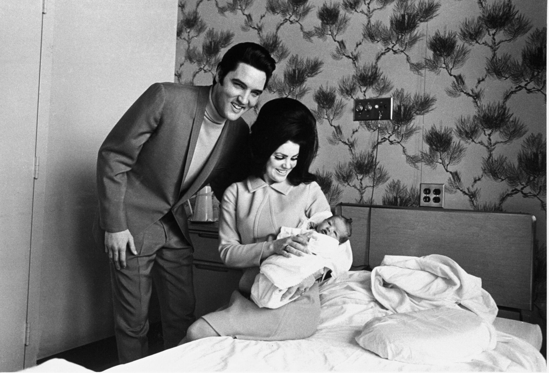 Lisa Marie Presley poses for her first picture, safe in the lap of her mother, Priscilla, on February 5, 1968, while proud father, Elvis Presley, beams his approval - Sputnik International, 1920, 13.01.2023