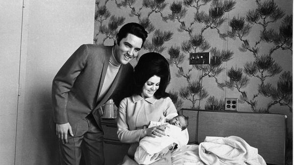 Lisa Marie Presley poses for her first picture, safe in the lap of her mother, Priscilla, on February 5, 1968, while proud father, Elvis Presley, beams his approval - Sputnik International