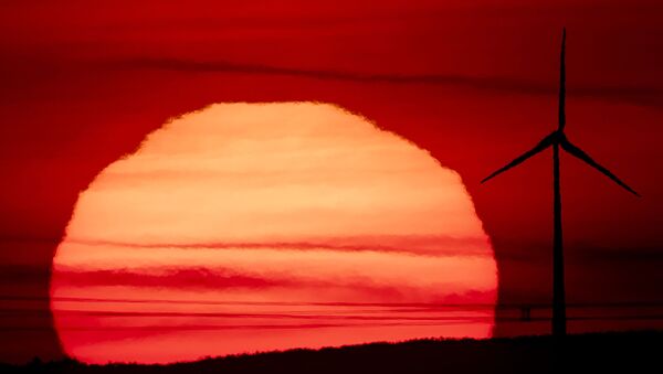The sun rises behind a wind turbine in Frankfurt, Germany, early Tuesday, Sept. 15, 2020. - Sputnik International