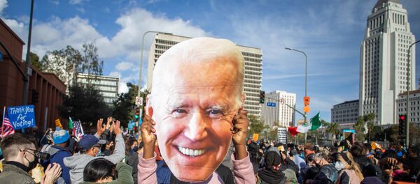 A woman holds a Joe Biden mask as people march in Los Angeles celebrating after Joe Biden was declared the winner of the 2020 presidential election on November 7, 2020. - Democrat Joe Biden has won the White House, US media said November 7, defeating Donald Trump and ending a presidency that convulsed American politics, shocked the world and left the United States more divided than at any time in decades. - Sputnik International