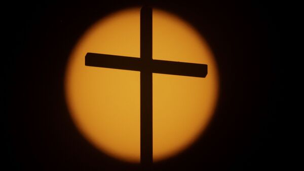 The cross on top of the First Baptist Church is silhouetted in front of the sun on Sunday, Aug. 20, 2017, in Simpsonville, S.C. South Carolina is gearing up for a total solar eclipse, which will cross the state diagonally during a phenomenon that will be seen across the country - Sputnik International