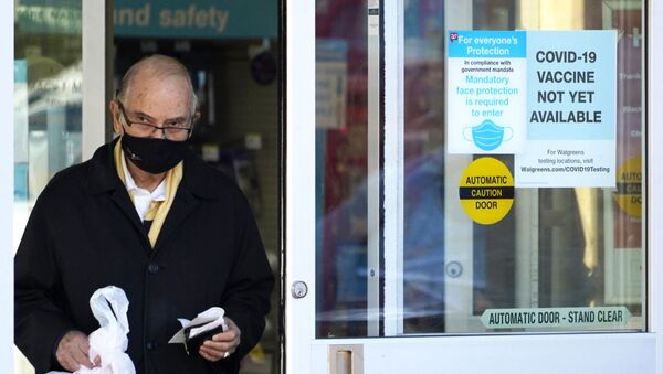 A customer wears a mask as he walks out of a Walgreen's pharmacy store and past a sign advising that a COVID-19 vaccine is not yet available at Walgreens in Northbrook, Ill., Thursday, Dec. 4, 2020 - Sputnik International