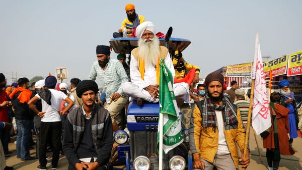 Farmers sit on a tractor during a protest against the newly passed farm bills at Singhu border near Delhi, India, December 5, 2020 - Sputnik International