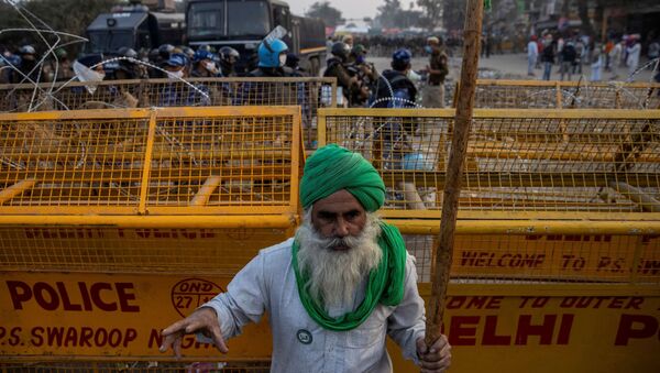  A farmer stands in front of police barricades during a protest against the newly passed farm bills at Singhu border near Delhi, India, December 3, 2020 - Sputnik International