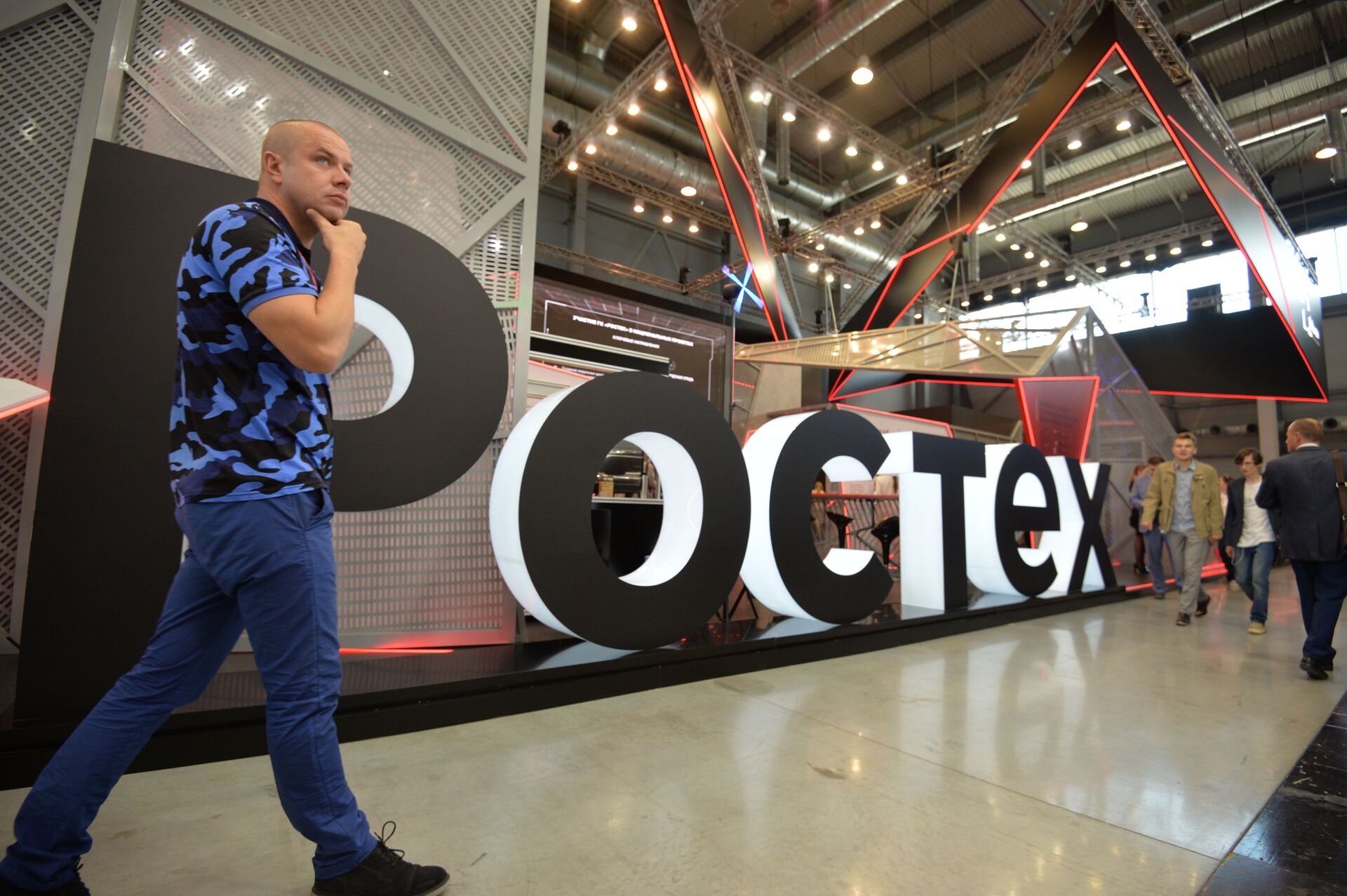 A visitor walks past Rostec's stand at the attends the Innoprom International Industrial Fair, in Yekaterinburg, Russia - Sputnik International, 1920, 07.09.2021