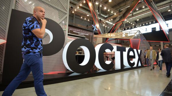 A visitor walks past Rostec's stand at the attends the Innoprom International Industrial Fair, in Yekaterinburg, Russia - Sputnik International